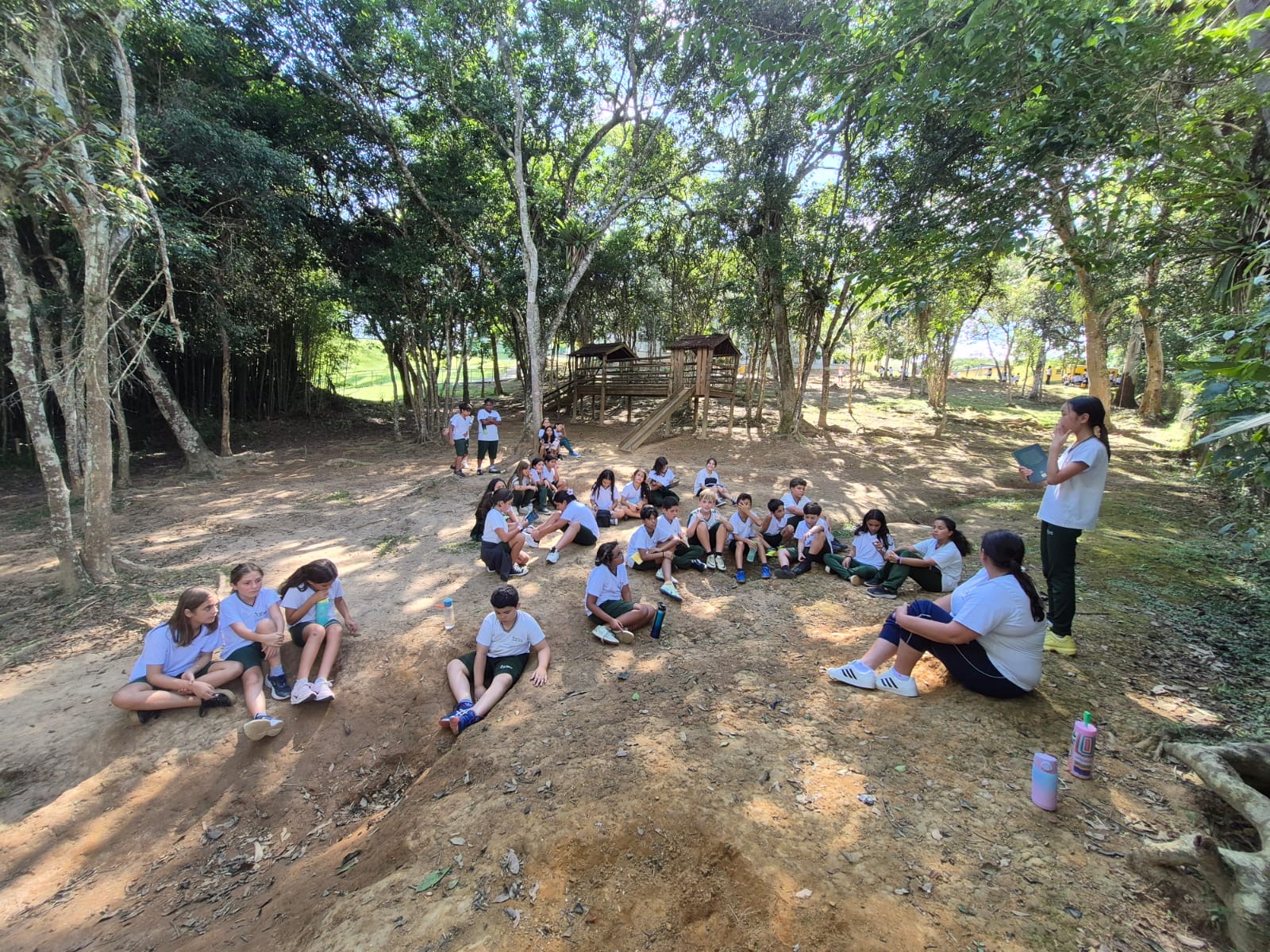 Alunos do Colégio 8 de Maio reunidos em uma área de mata do campus